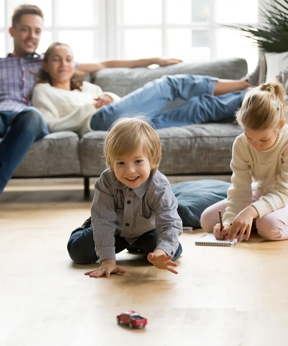 Parents watching kids play in living room