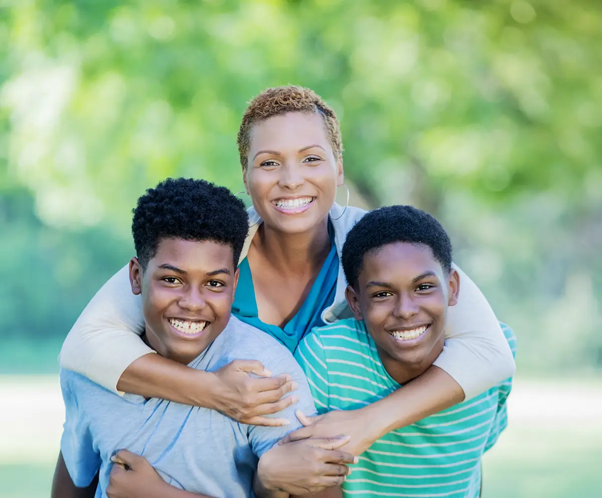 Mom smiles for camera with her two teenage sons