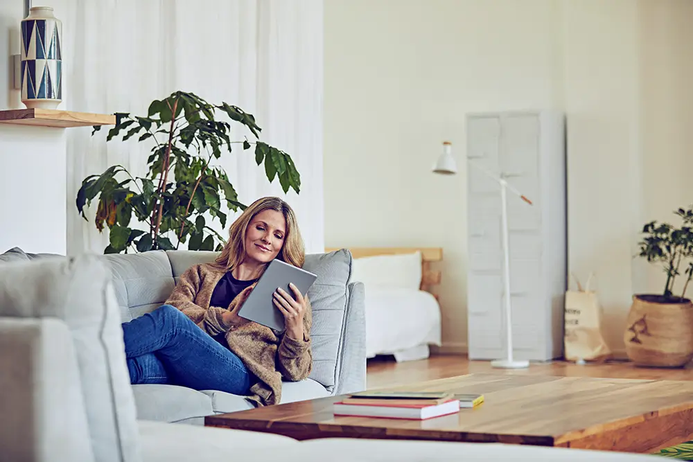 Woman relaxing in a sofa using her smart tablet