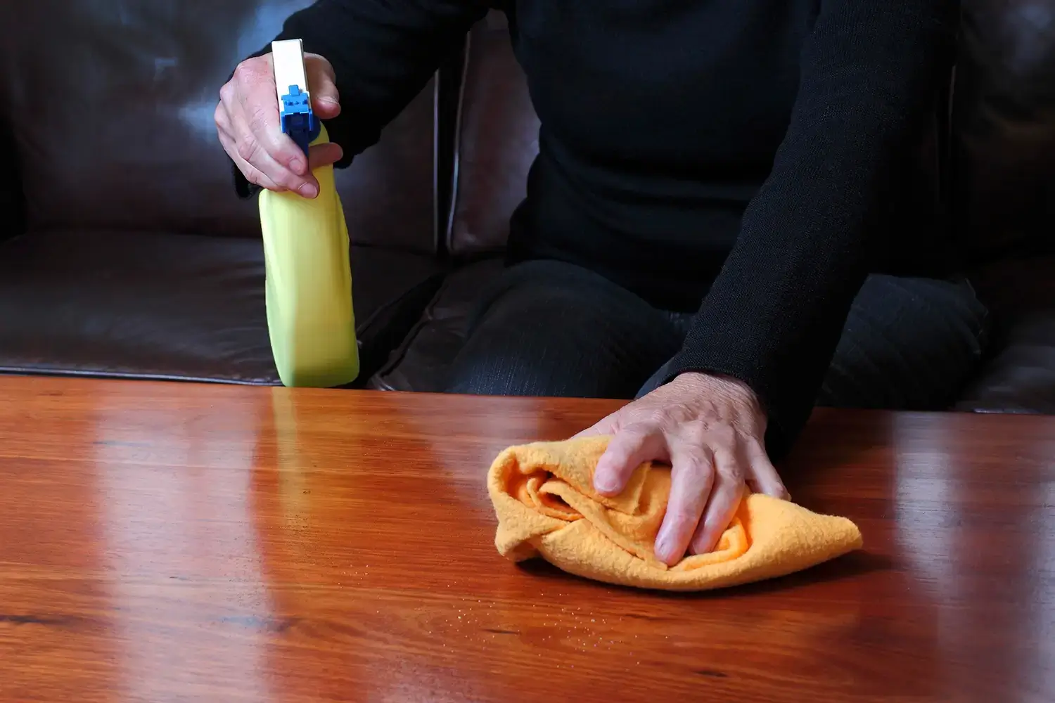Person cleaning wood surfce with a cloth