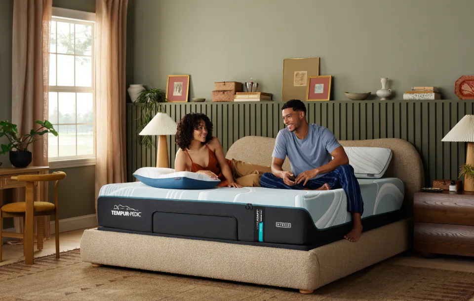 Couple laying on mattress and smiling