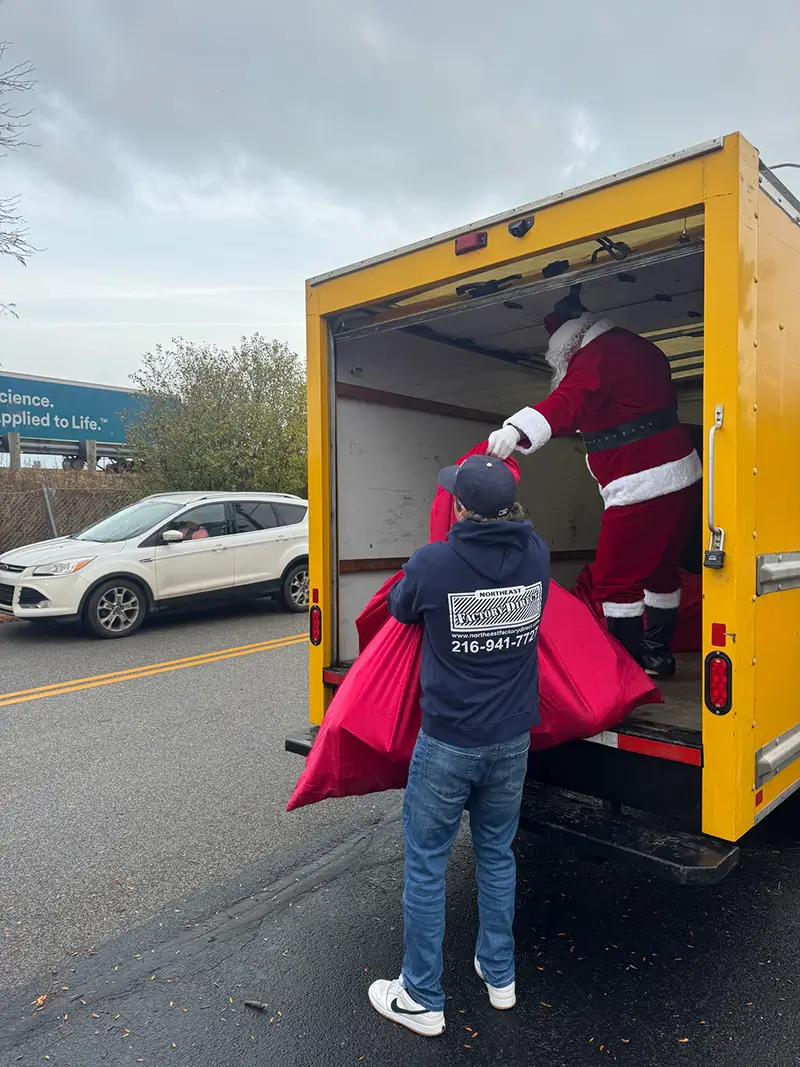 Santa loading donation bags into an NEFD delivery truck